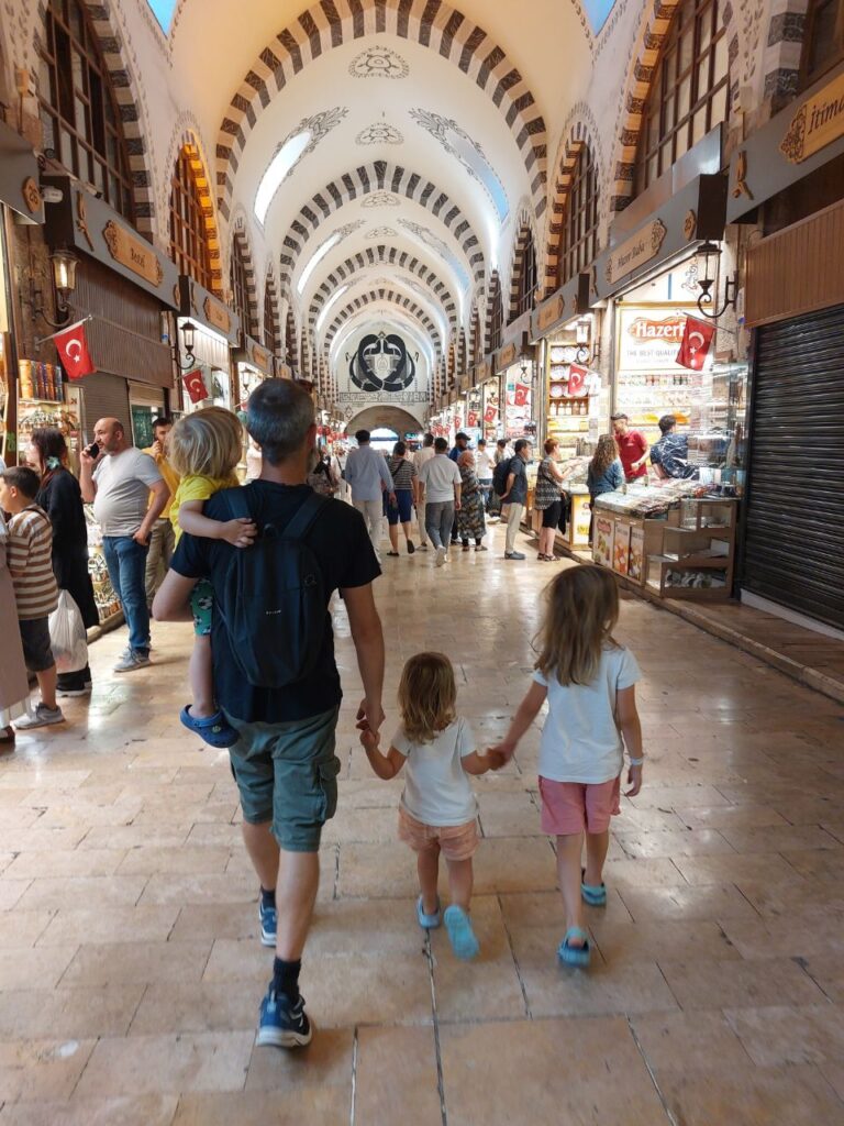 un hombre con tres ninos caminando en el mercado de Istanbul