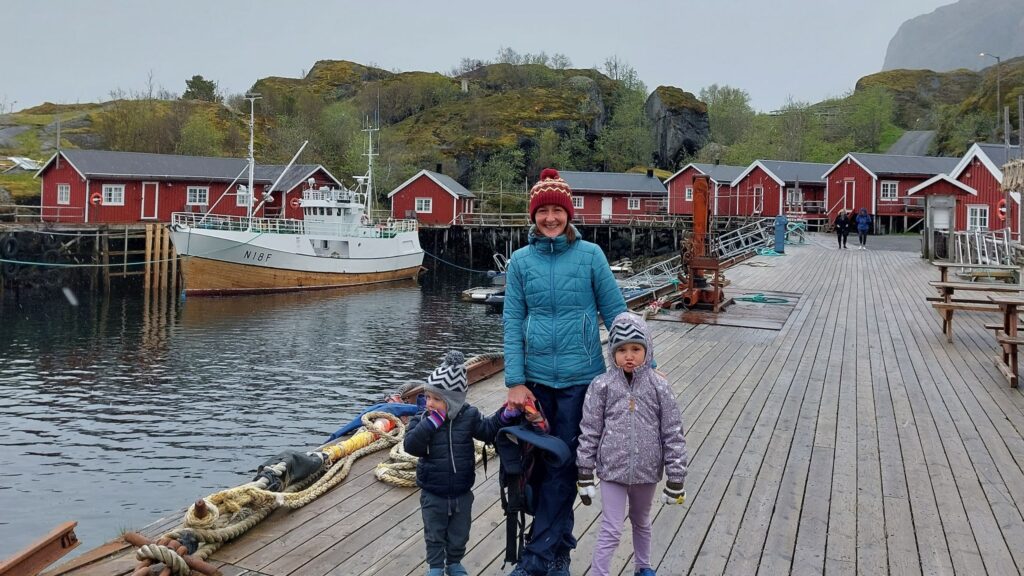 familia enfrente del mar y cabanas de madera en islas lofoten