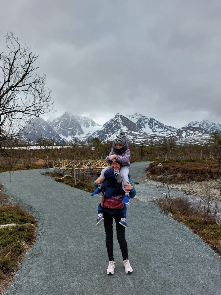 Mujer con dos ninos en la caminata enfrente de la montana en Noruega