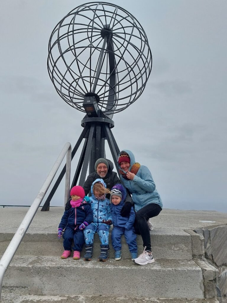 familia enfrente de globo en Cabo Norte en Noruega