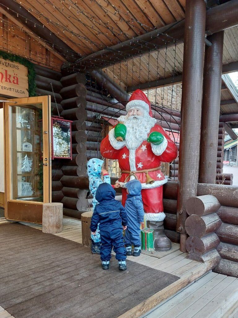 Ninos con la figura de Papa Noel en Rovaniemi, Finlandia