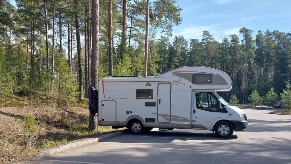 Autocaravana aparcada en el parking en bosque cerca de Helsinki