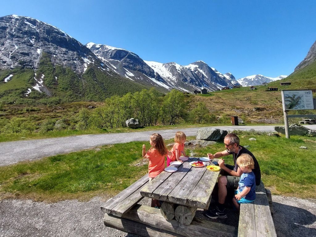 Noruega familia comiendo en la mesa, en fondo montanas