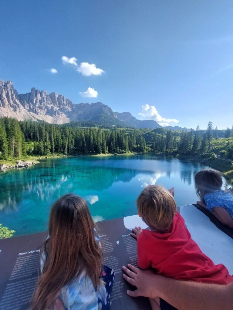tres ninos mirando al lago di Carezza en dolomitas Italia