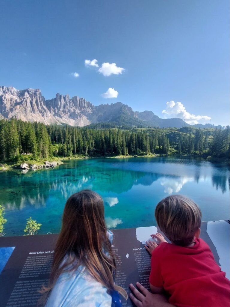 dos ninos mirando al lago di carezza en dolomitas, italia