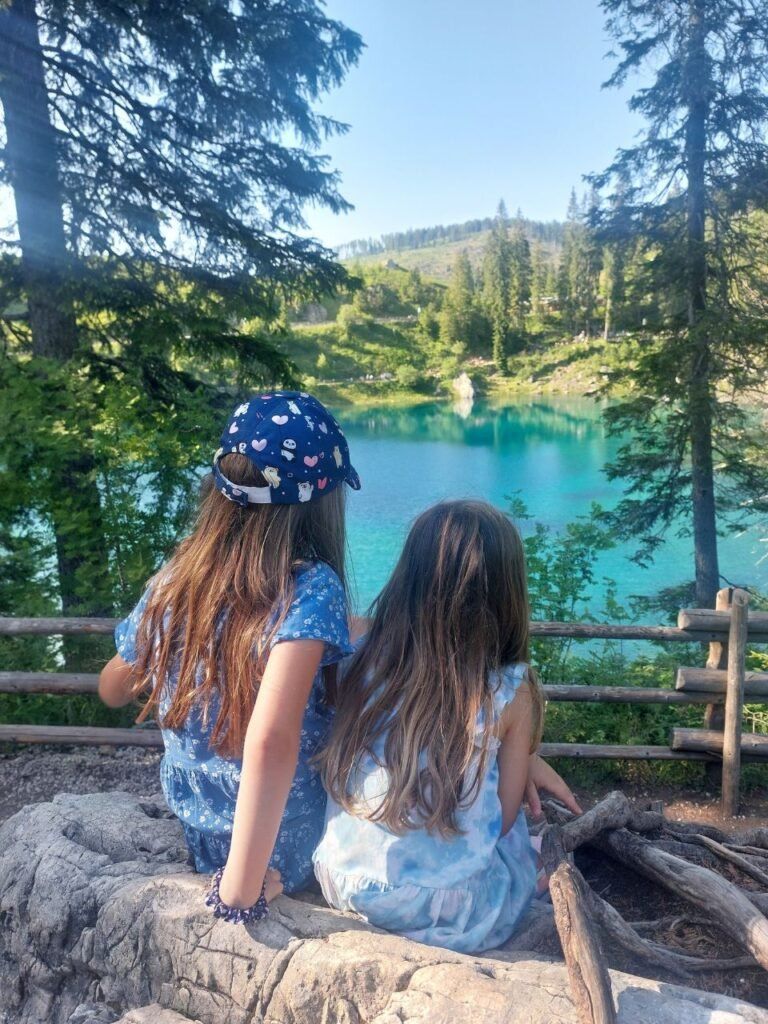 dos ninas mirando al lago di Carezza en Dolomitas, Italia