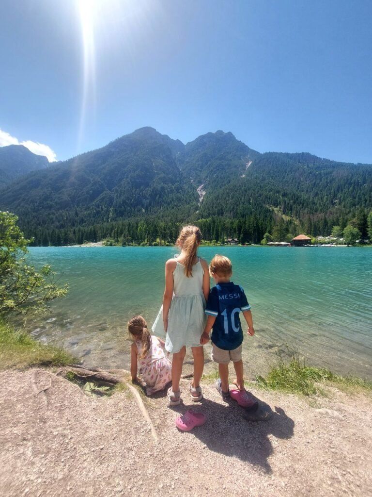 Tres ninos delante de Lago di Dobiacco en Dolomitas Italia
