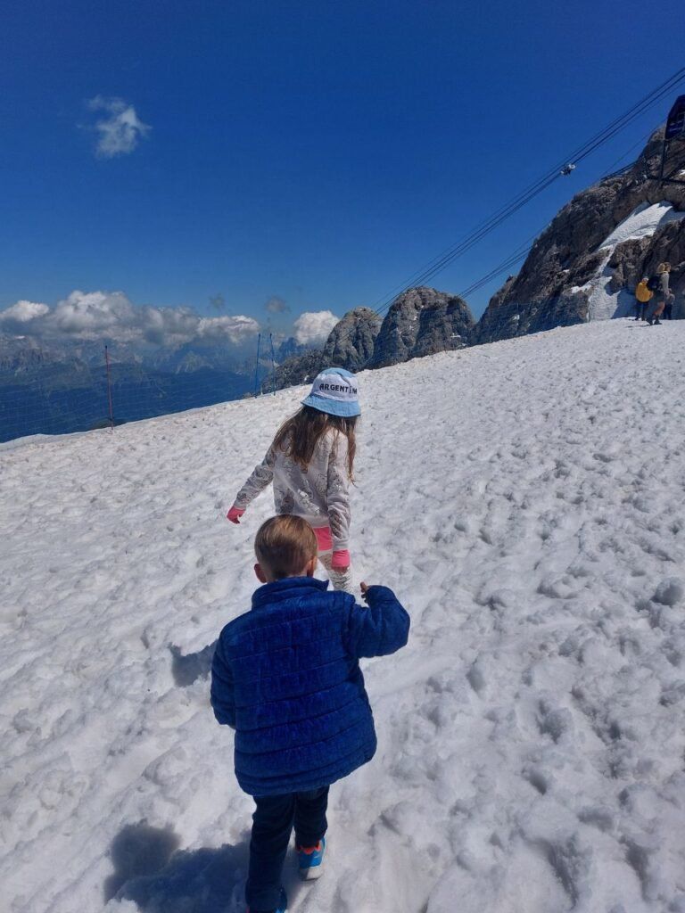 Ninos jugando en la nieve en Dolomitas, Italia
