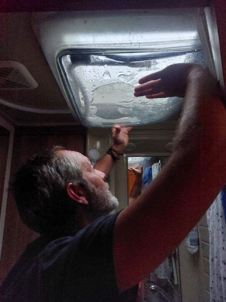 Hombre aguantando claraboya en autocaravana