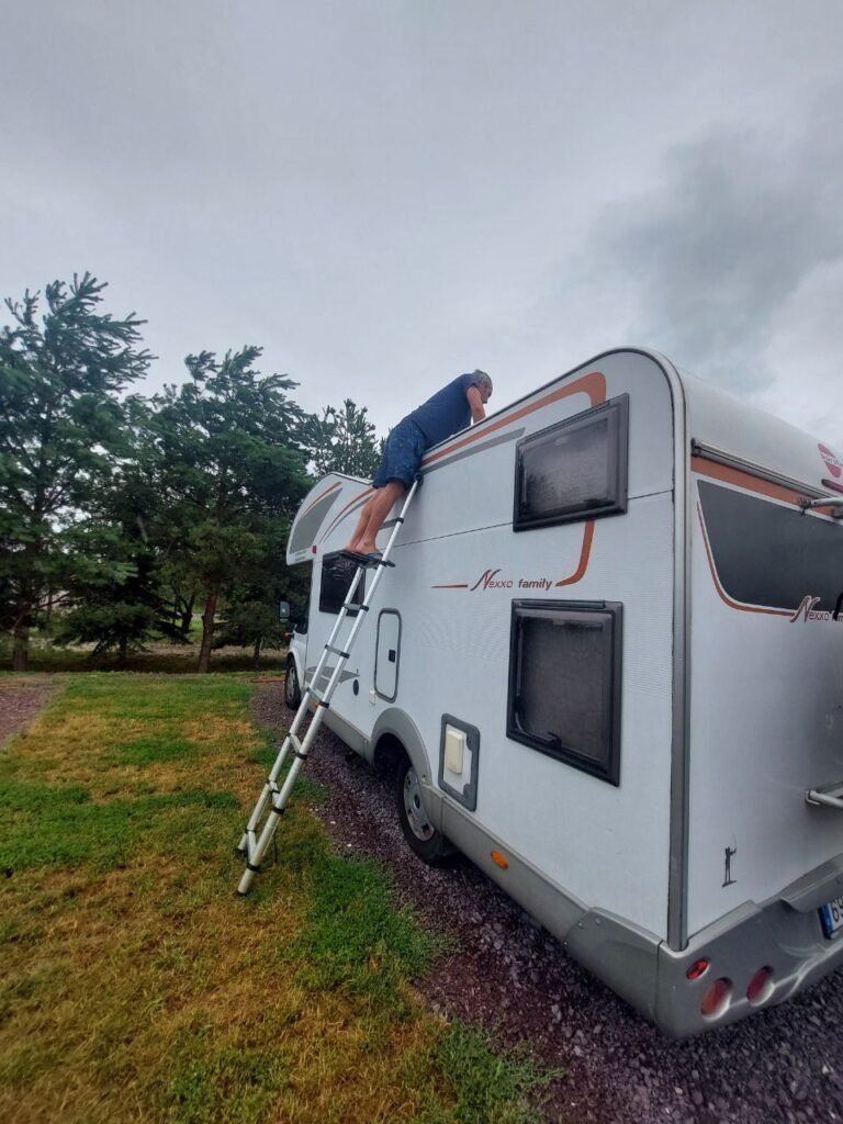 Hombre subiendo al techo de autocaravana