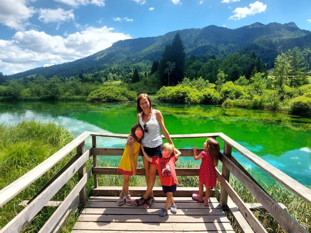 una mujer con tres ninos delante del lago en eslovenia