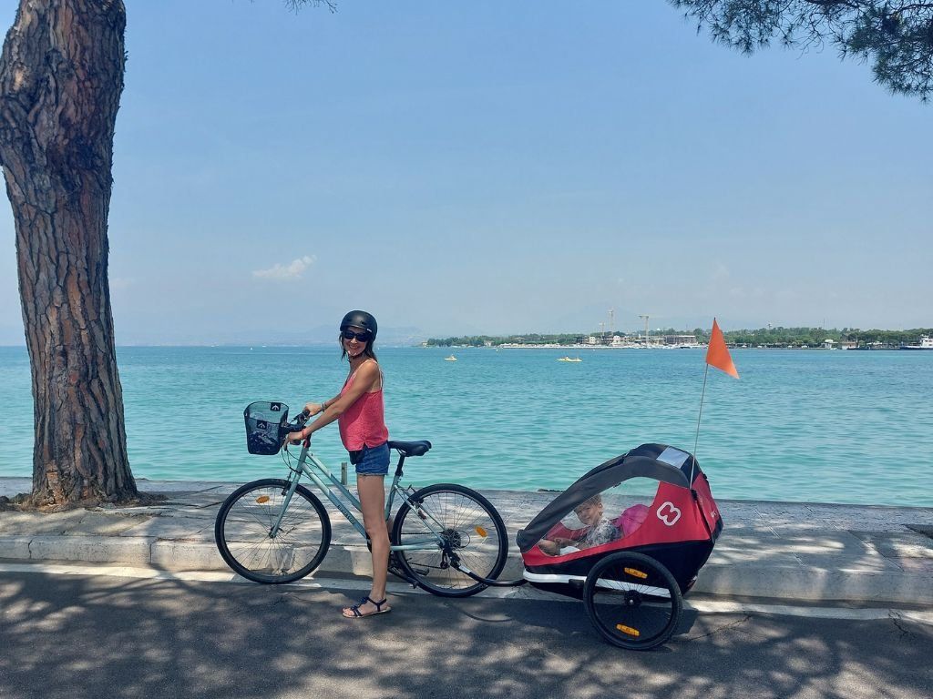 Mujer delante de lago di garda en bicicleta