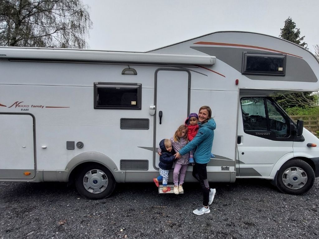 Familia delante de una autocaravana