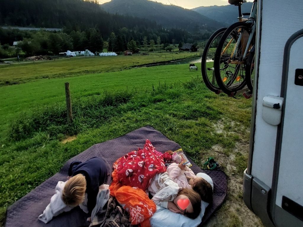 ninos durmiendo al lado de autocaravana
