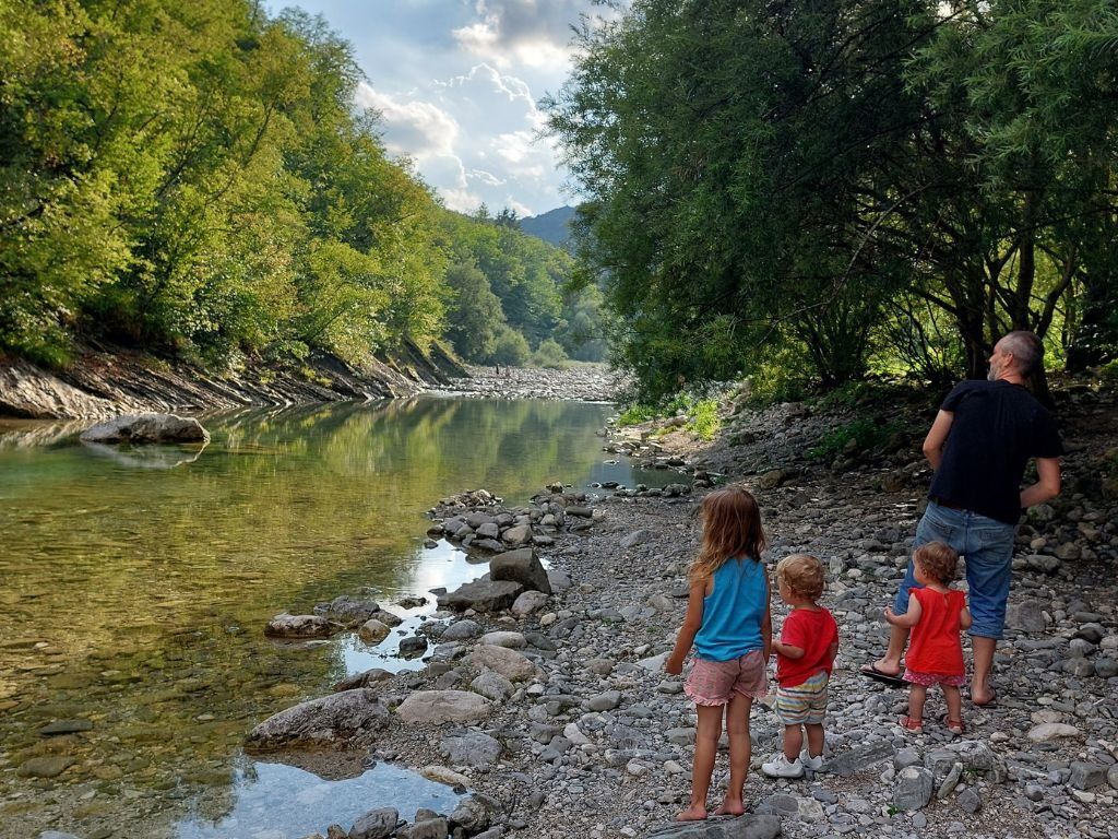 tres ninos delante del rio. viajar con ninos 